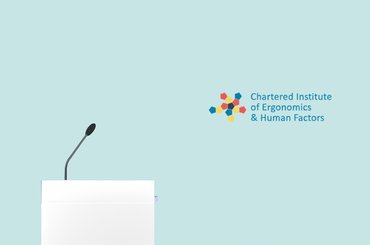 Podium with a gooseneck microphone against a light teal background, alongside the Chartered Institute of Ergonomics and Human Factors logo.