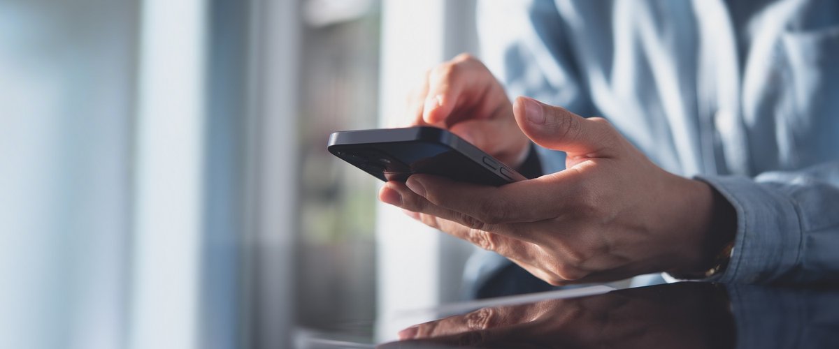 Close up of hands using a smart phone.