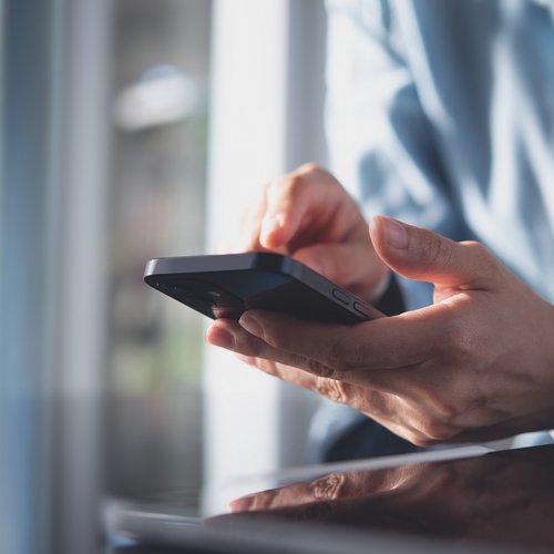 Close up of hands using a smart phone.
