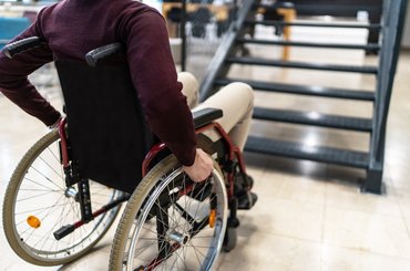 A male wheelchair user is unable to use an internal staircase for access to the next level.