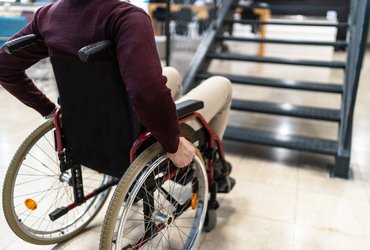 A male wheelchair user is unable to use an internal staircase for access to the next level.