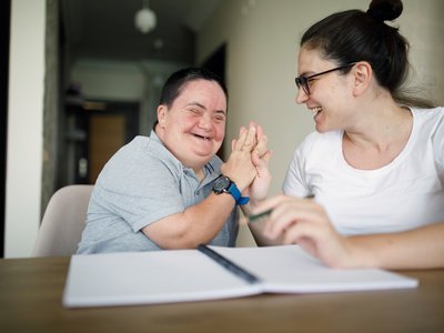 Picture shows a person with a learning disability being supported during a one-on-one activity